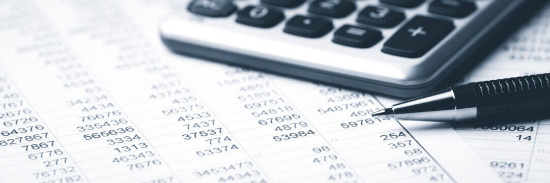 Spreadsheet with an assortment of numbers, calculator, and pen